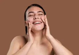 Mulher sorridente lavando o rosto com pele com acne